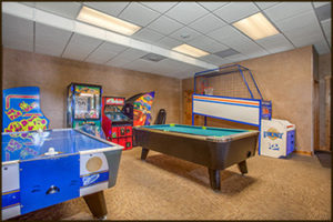 Recreation room with pool table, air hockey, arcade games, and carpeted flooring